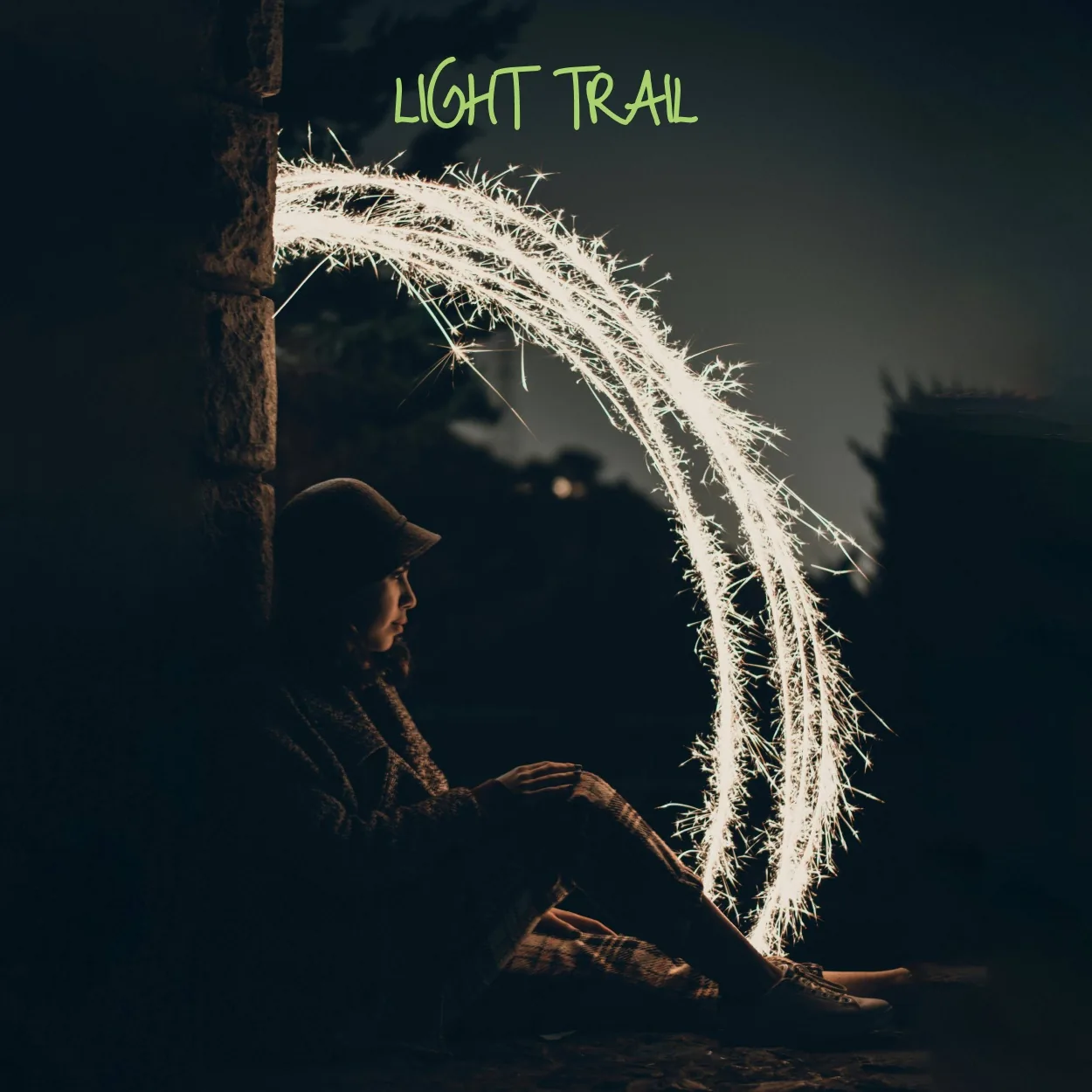Light trail example: a person drawing an arc of light at night